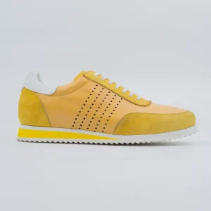 A pair of vibrant yellow Calvano durable leather sneakers with white laces on a white background, showcasing their quality craftsmanship and robust build.